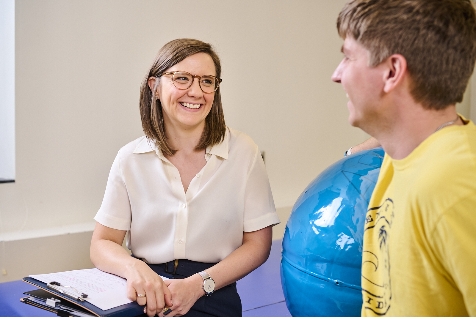 A marriage and family therapist engages in a counseling session with a patient's husband, providing psychological support services for family members.